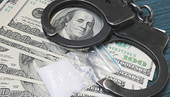 A bag of drugs, US dollars and handcuffs on the table